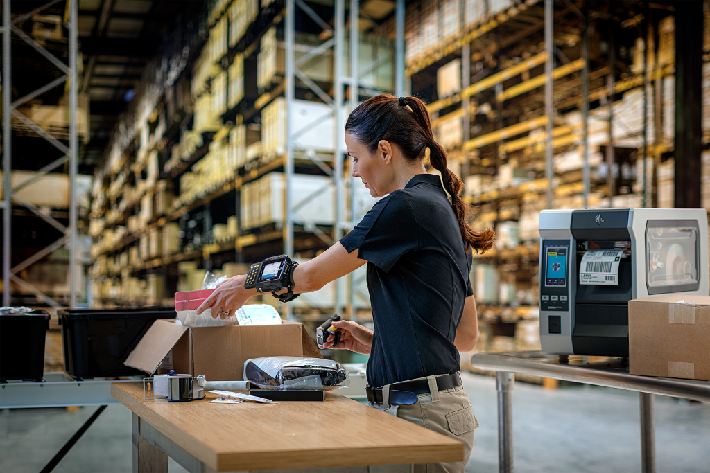 Warehouse worker applying barcode label to packaging.