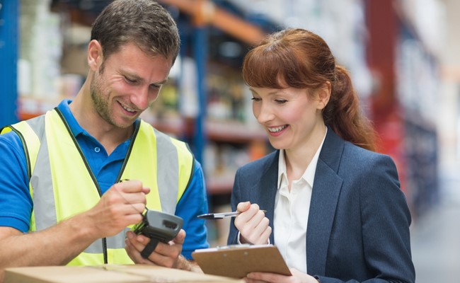 warehouse associate shows manager qstock inventory data on barcode scanner